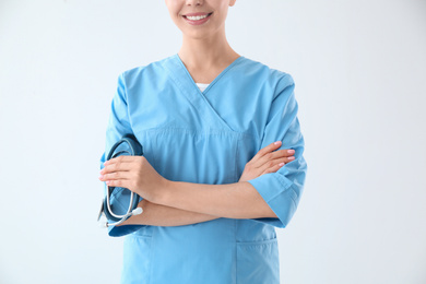 Photo of Young doctor on light background, closeup. Medical service