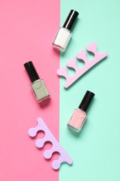 Photo of Nail polishes and toe separators on color background, flat lay