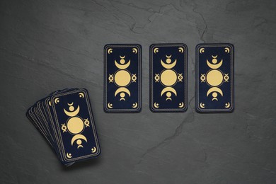 Photo of Tarot cards on black table, flat lay. Reverse side
