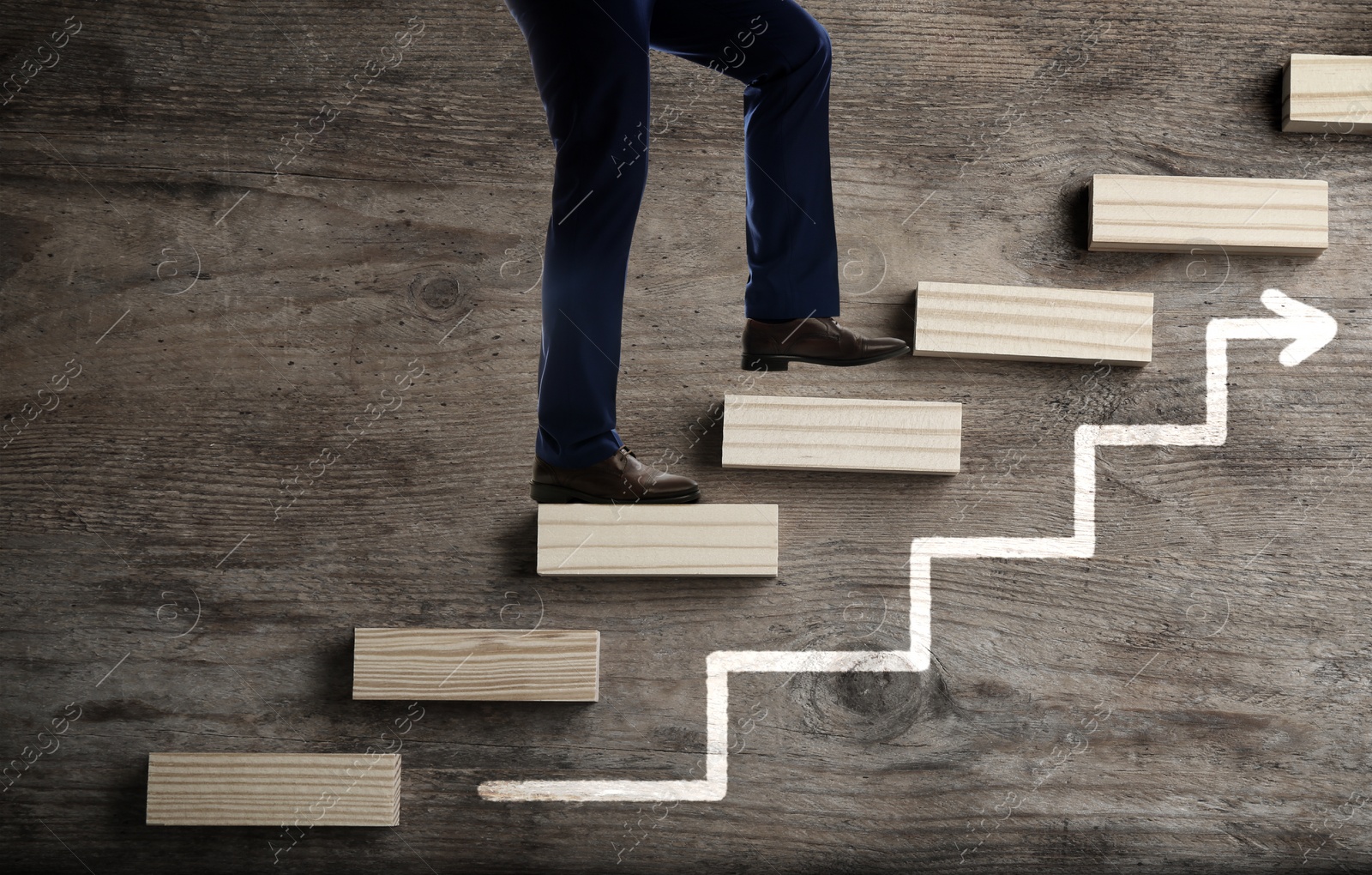 Image of Businessman walking up stairs against wooden background, closeup. Career ladder concept