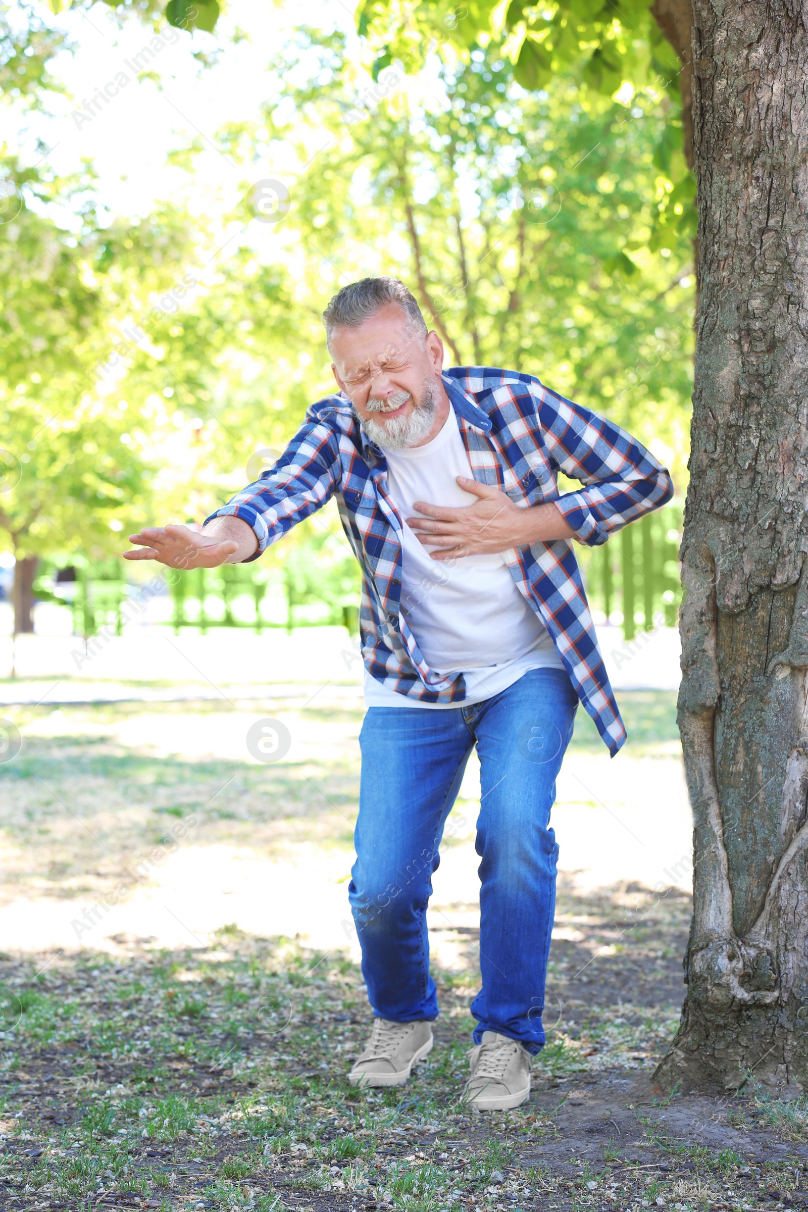 Photo of Mature man having heart attack in park