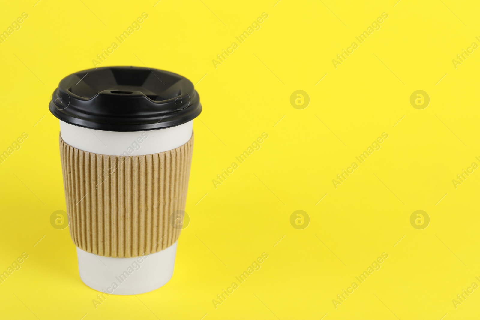 Photo of Paper cup with plastic lid on yellow background, space for text. Coffee to go