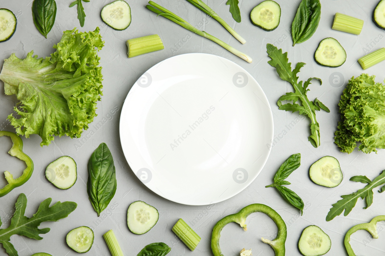 Photo of Flat lay composition with fresh salad ingredients on grey background, space for text