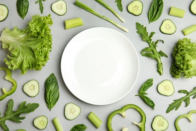 Photo of Flat lay composition with fresh salad ingredients on grey background, space for text