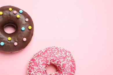 Photo of Delicious glazed donuts on pink background, flat lay. Space for text