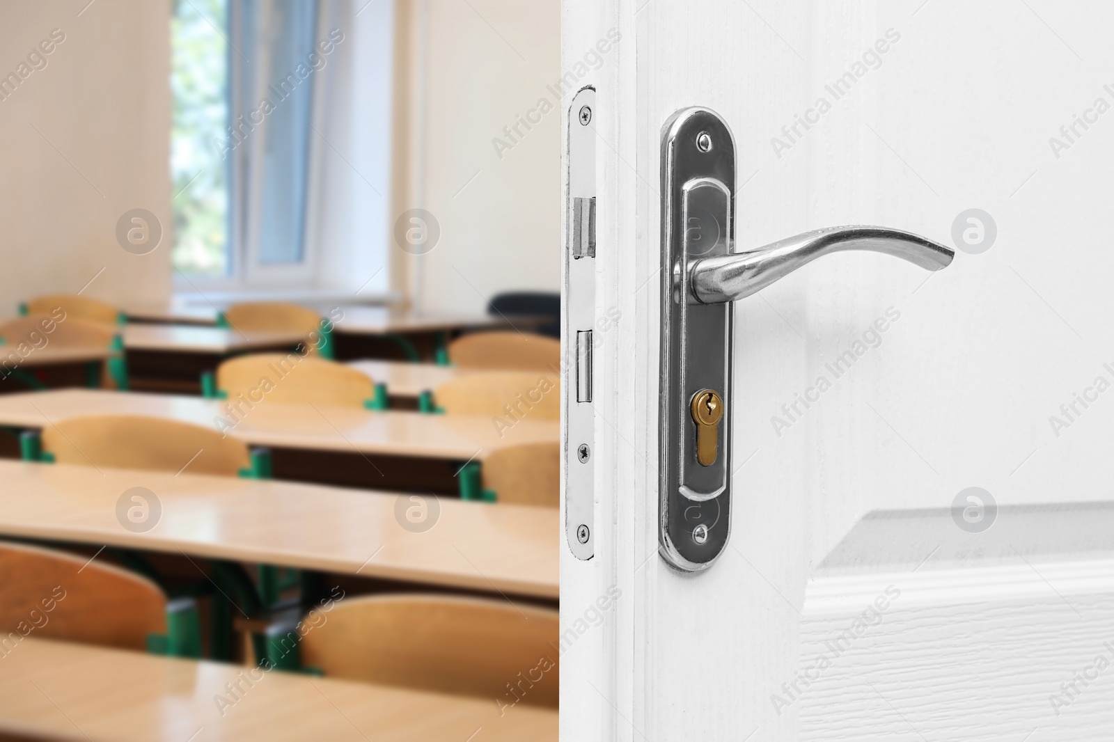 Image of Wooden door open into modern empty classroom