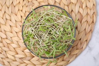Mung bean sprouts in glass bowl on white table, top view