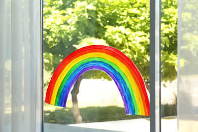 Photo of Painting of rainbow on window indoors. Stay at home concept