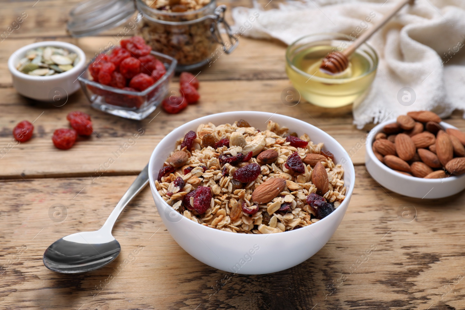 Photo of Tasty granola served with nuts and dry fruits on wooden table