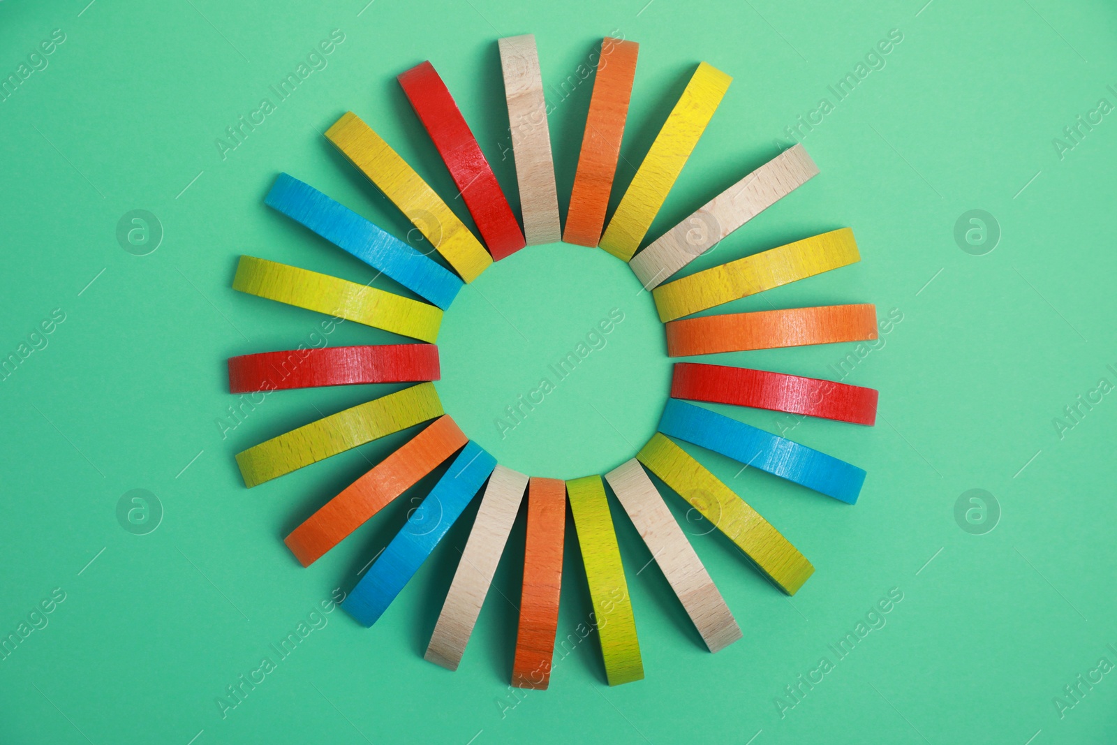 Photo of Colorful wooden pieces of play set on green background, flat lay. Educational toy for motor skills development