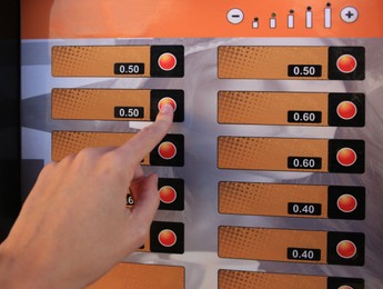 Using coffee vending machine. Woman pressing button to choose drink, closeup
