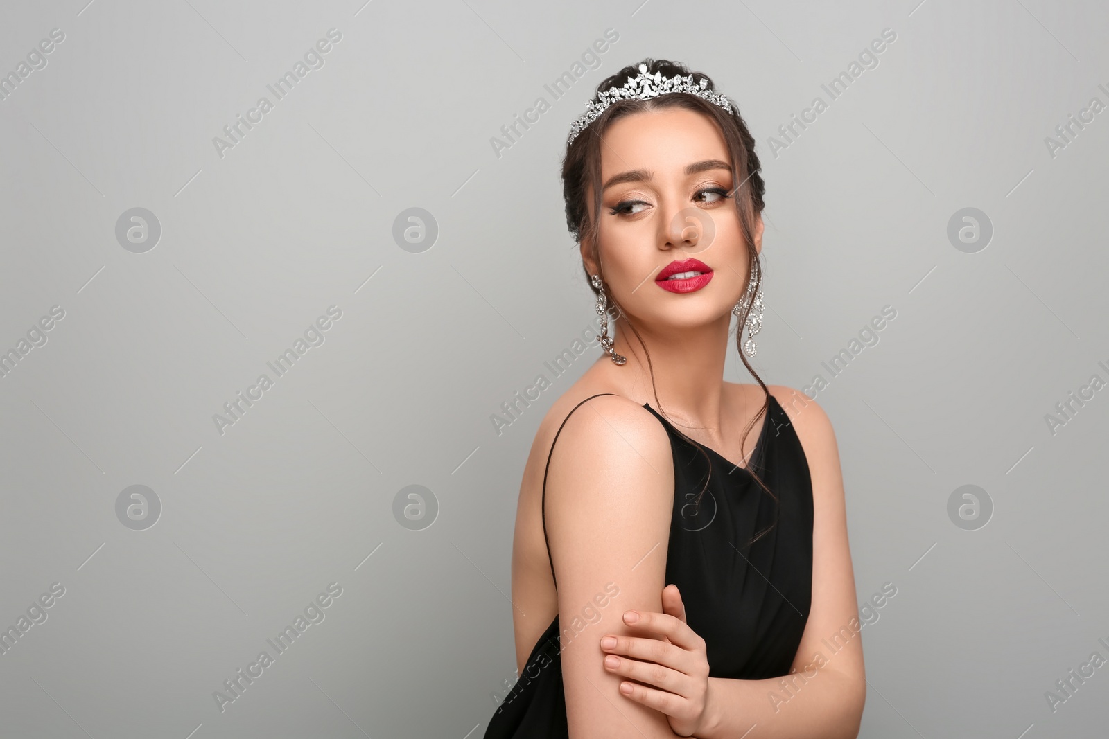 Photo of Beautiful young woman wearing luxurious tiara on light grey background, space for text