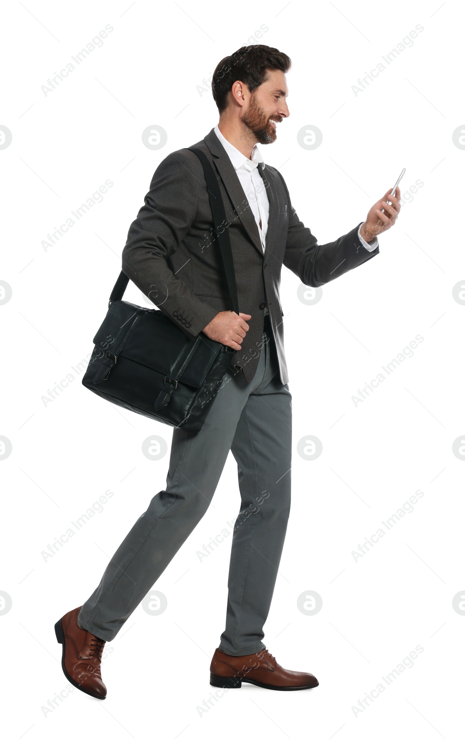 Photo of Handsome man with smartphone and black bag walking on white background
