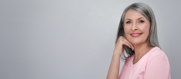 Image of Portrait of beautiful mature woman on light grey background. Banner design with space for text