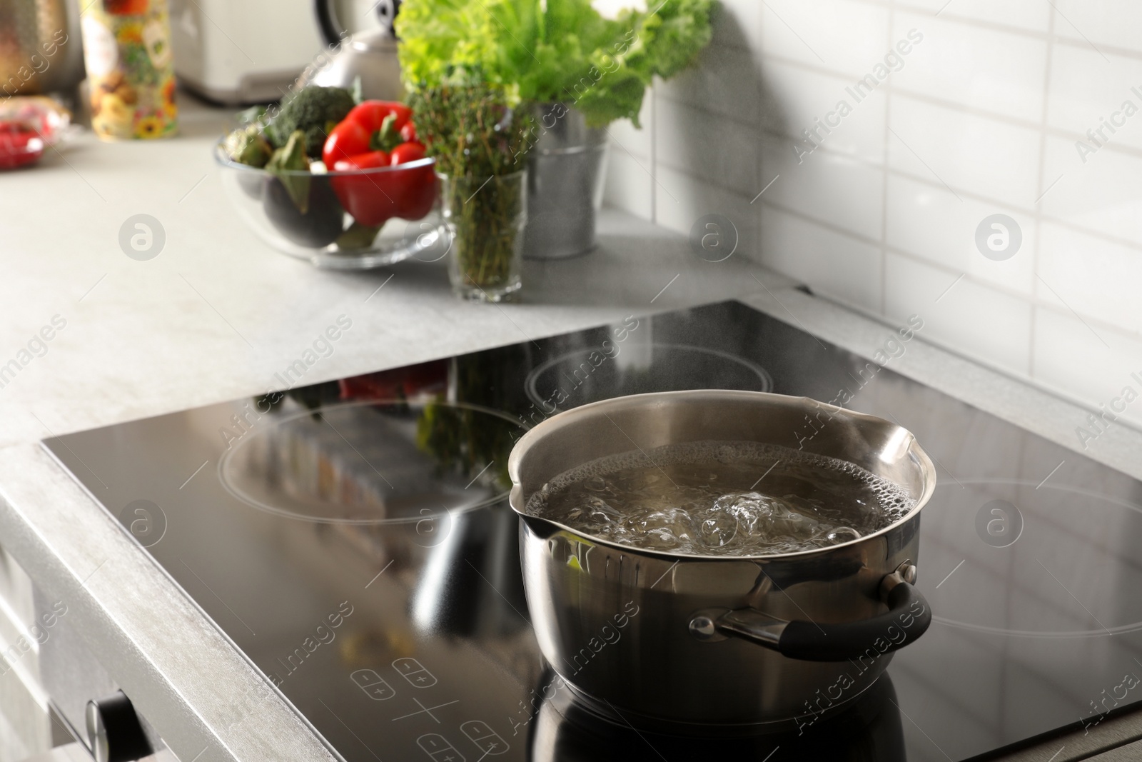 Photo of Pot with boiling water on electric stove in kitchen, space for text