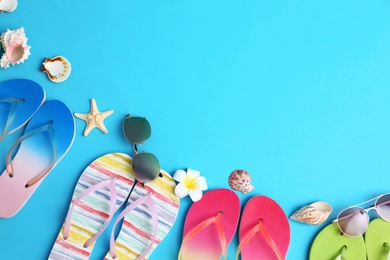 Photo of Flat lay composition with different flip flops on blue background, space for text. Summer beach accessories