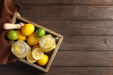 Photo of Mason jars with natural lemonade in wooden crate, top view