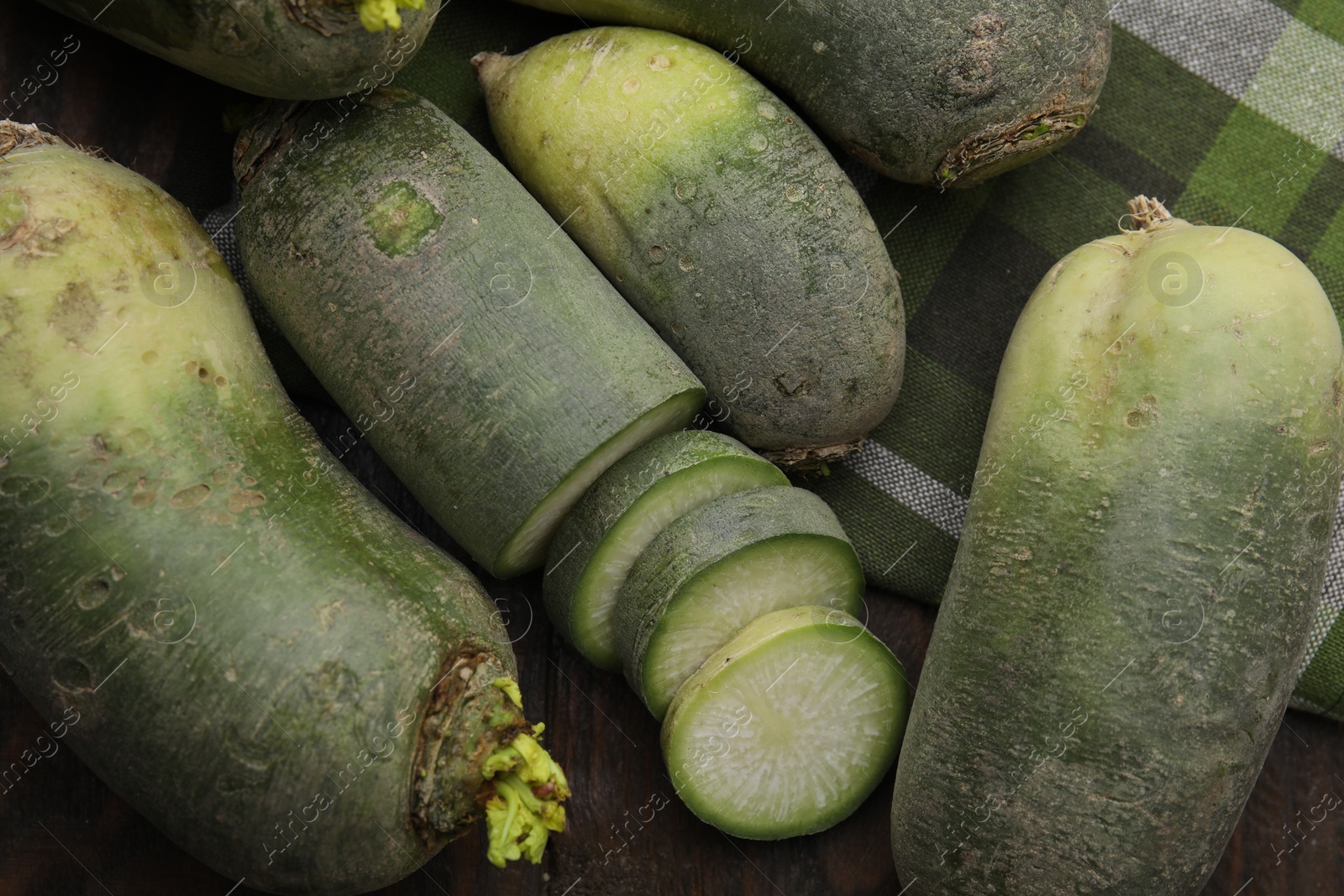 Photo of Green daikon radishes on wooden table, flat lay