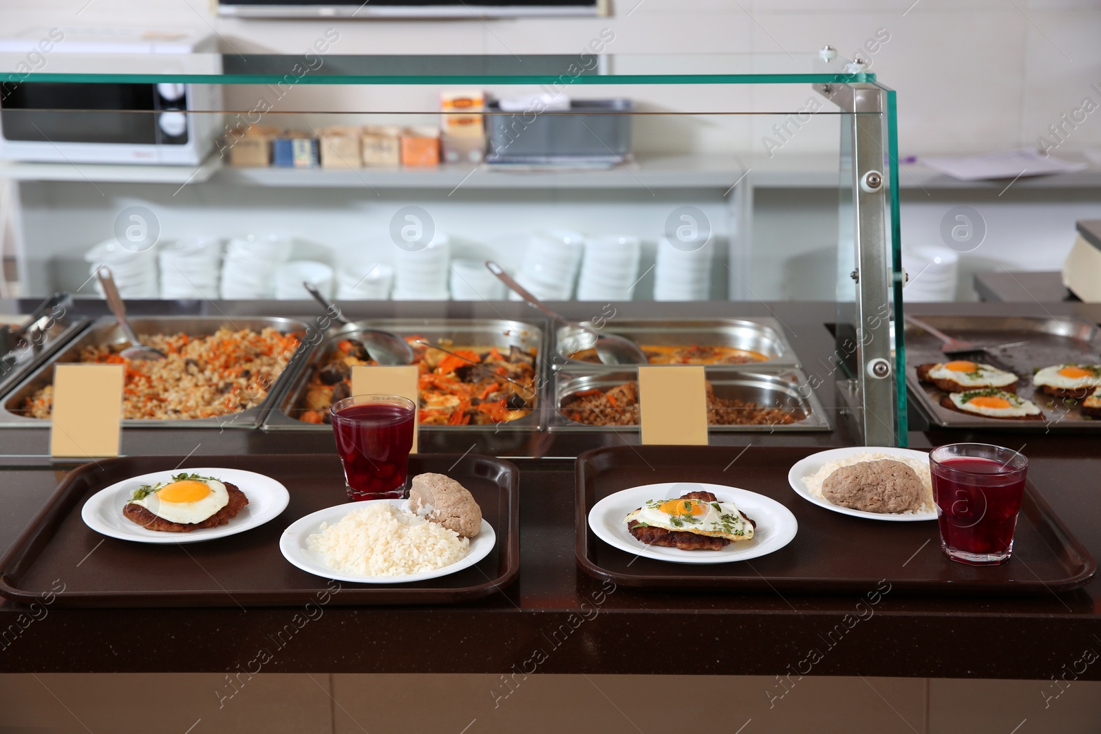 Photo of Trays with healthy food on serving line in school canteen