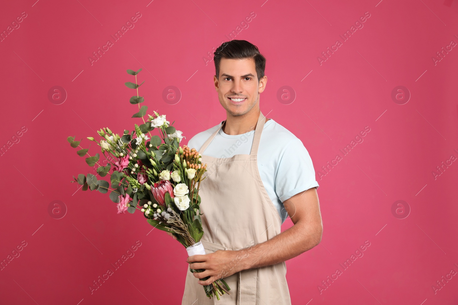 Photo of Florist with beautiful bouquet on pink background