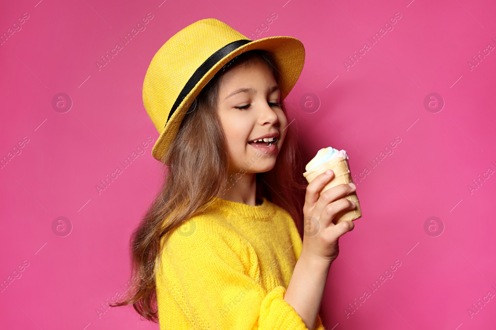 Photo of Adorable little girl with delicious ice cream against color background