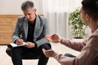 Photo of Professional psychotherapist working with patient in office