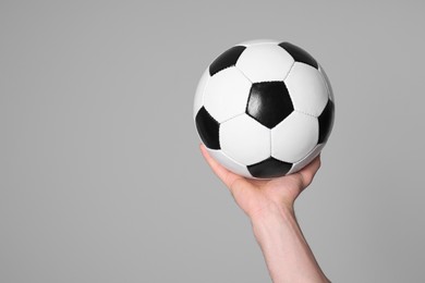 Photo of Man with soccer ball on light grey background, closeup. Space for text