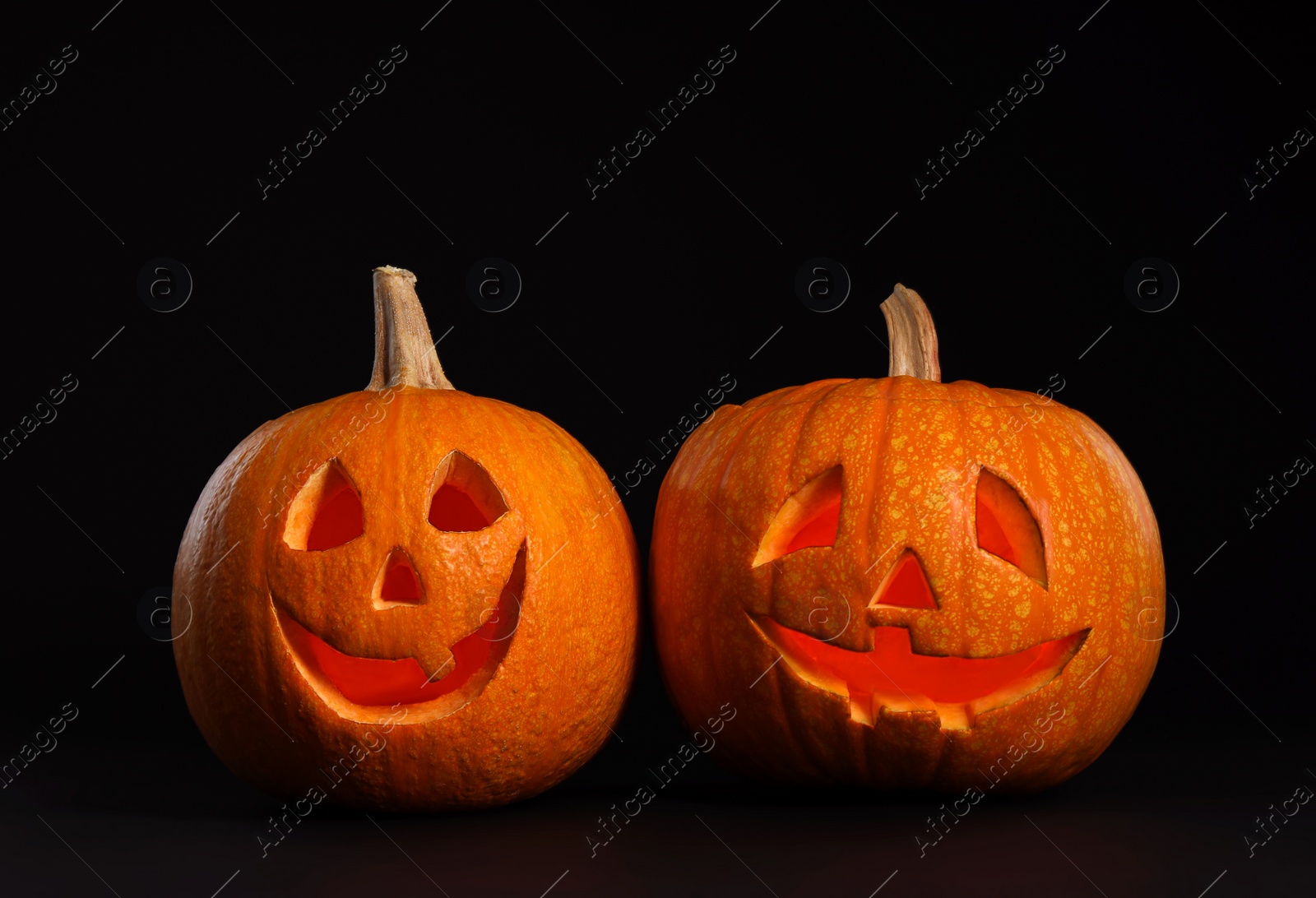 Photo of Pumpkin heads on black background. Jack lantern - traditional Halloween decor