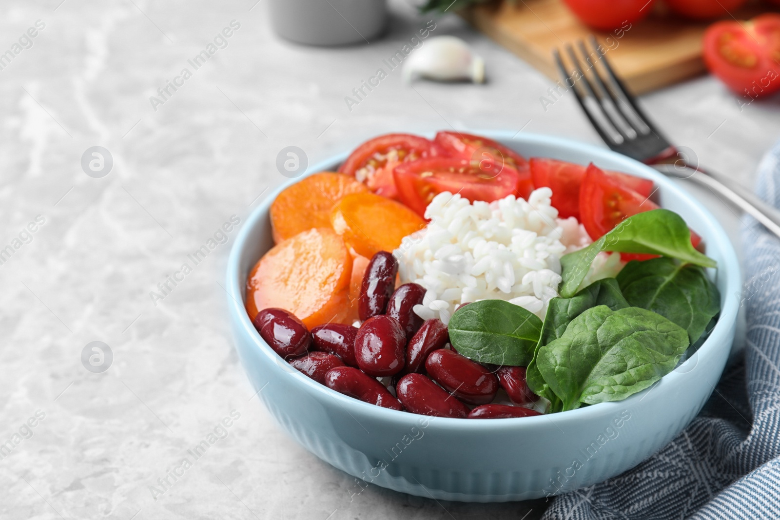 Photo of Tasty rice with beans served on light grey table, closeup