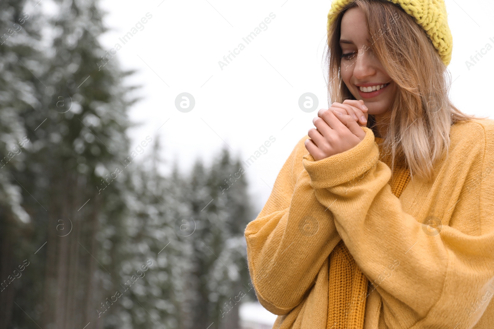 Photo of Young woman in warm clothes outdoors, space for text. Winter vacation