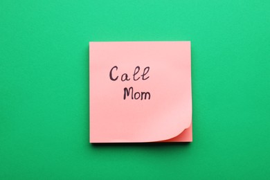 Paper note with words Call mom on green background, top view