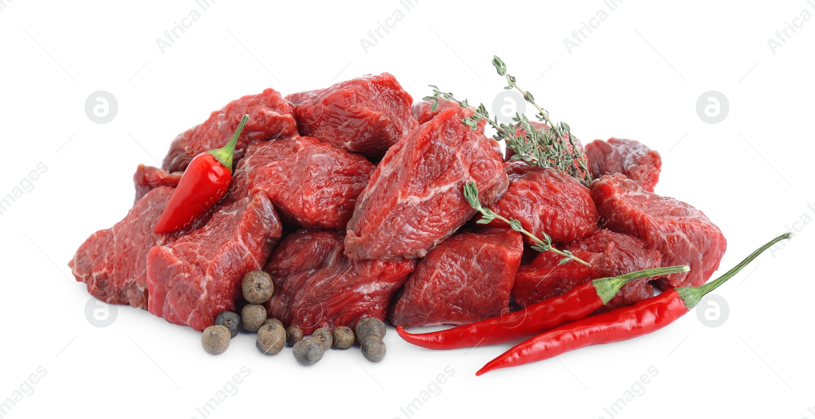 Photo of Pieces of raw beef meat, thyme sprigs, chili and peppercorns isolated on white