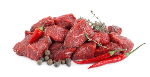 Photo of Pieces of raw beef meat, thyme sprigs, chili and peppercorns isolated on white