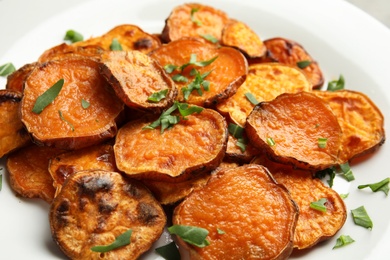 Plate with baked sweet potato slices, closeup