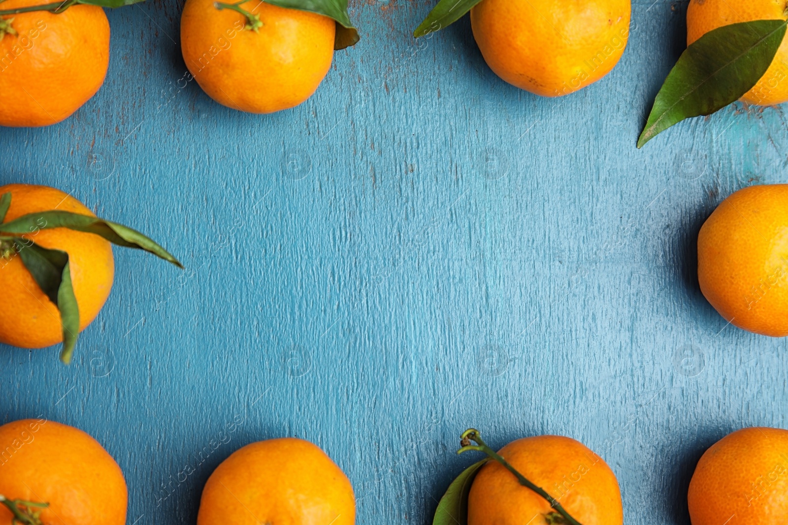 Photo of Fresh ripe tangerines and space for text on wooden background, top view