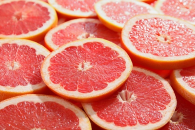 Photo of Many sliced fresh ripe grapefruits as background, closeup