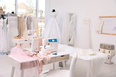 Photo of Dressmaking workshop interior with wedding dresses and equipment