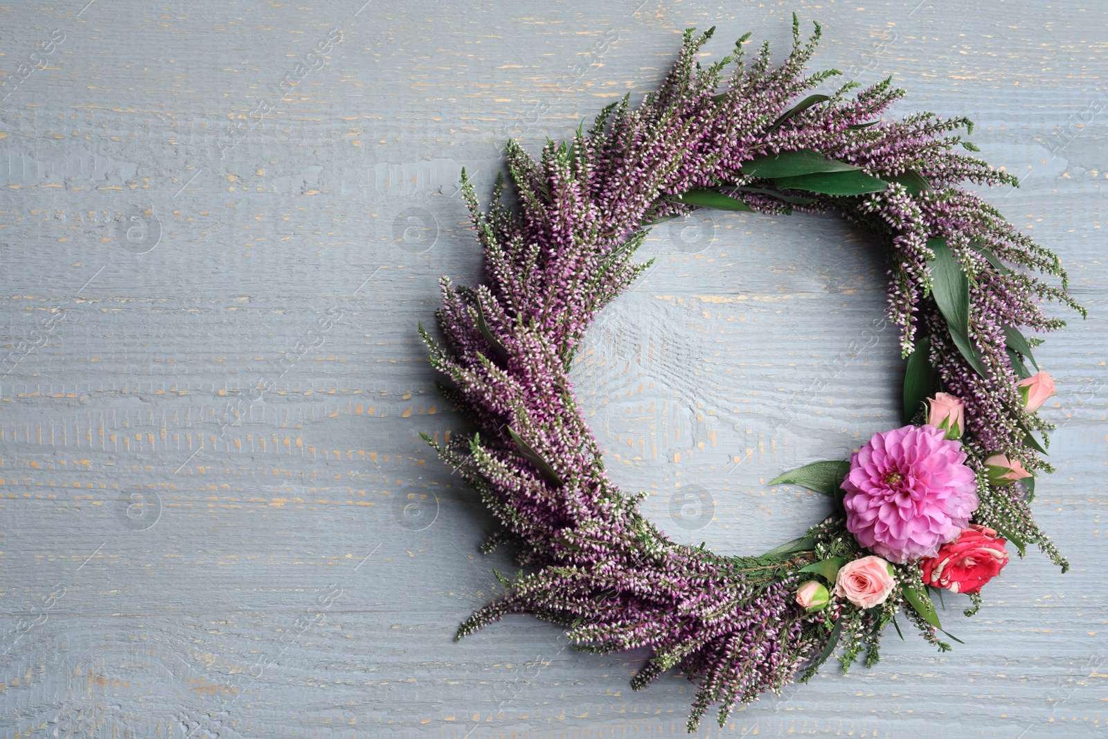 Photo of Beautiful autumnal wreath with heather flowers on light grey wooden background, top view. Space for text