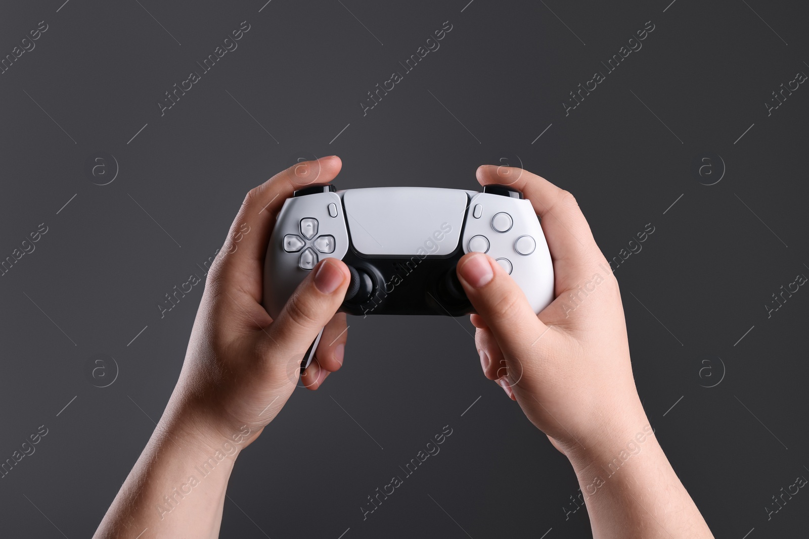 Photo of Woman using wireless game controller on dark background, closeup