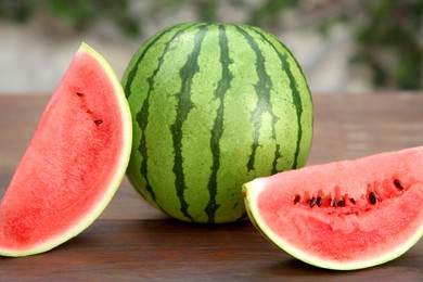 Delicious whole and cut watermelons on wooden table