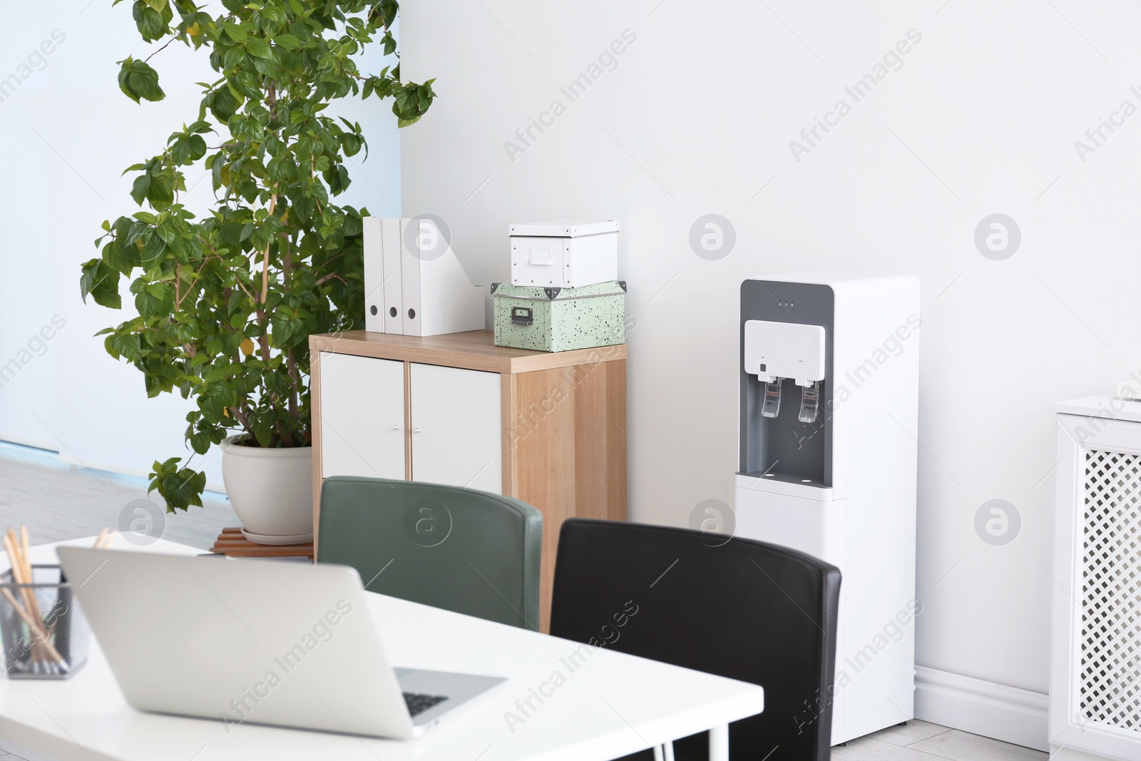 Photo of Modern water cooler in stylish office interior