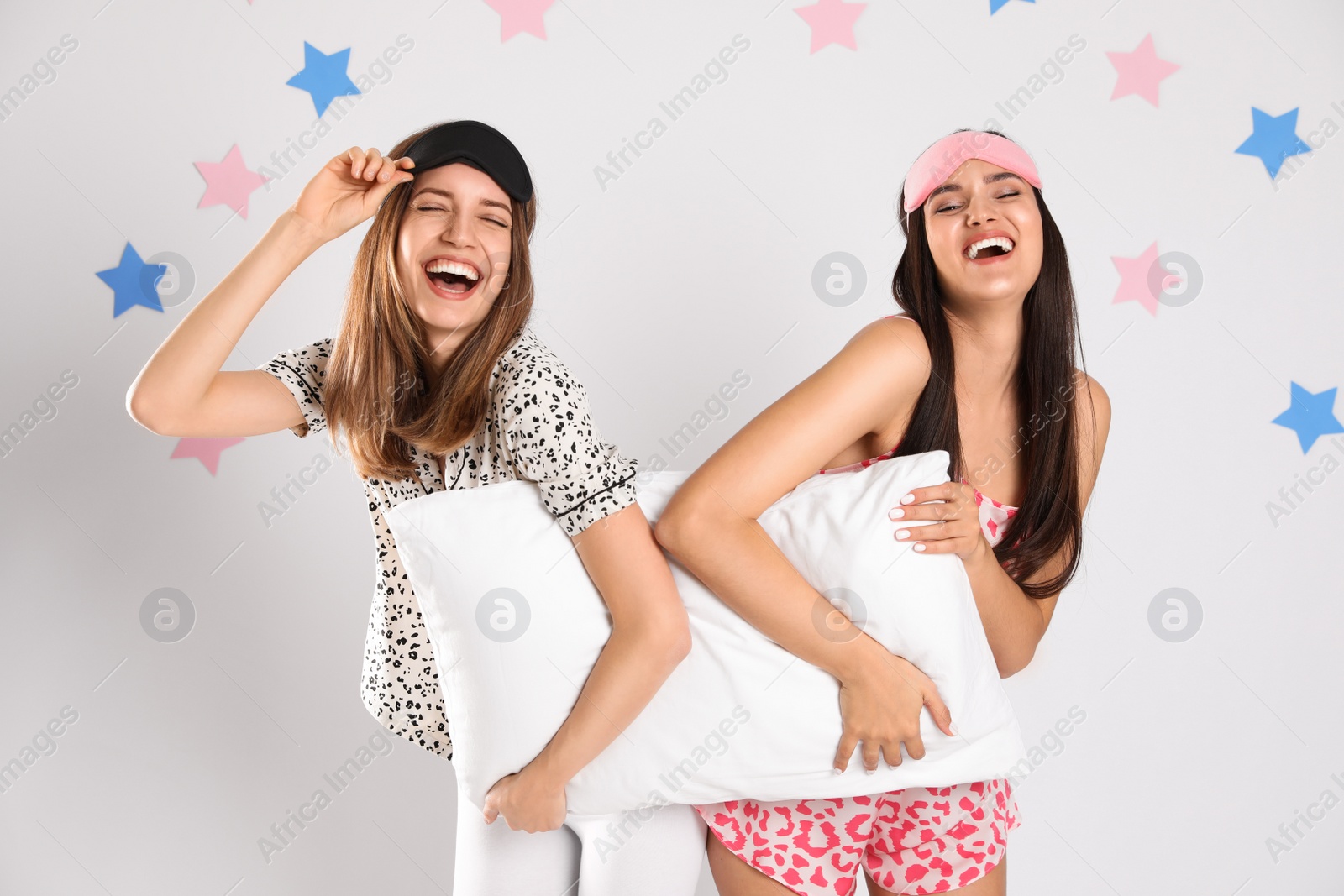 Photo of Beautiful women with pillow on light grey background. Bedtime