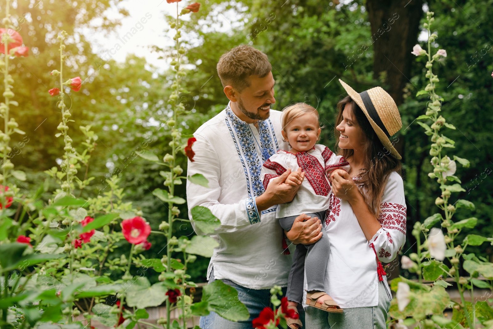 Photo of Happy family in Ukrainian national clothes outdoors