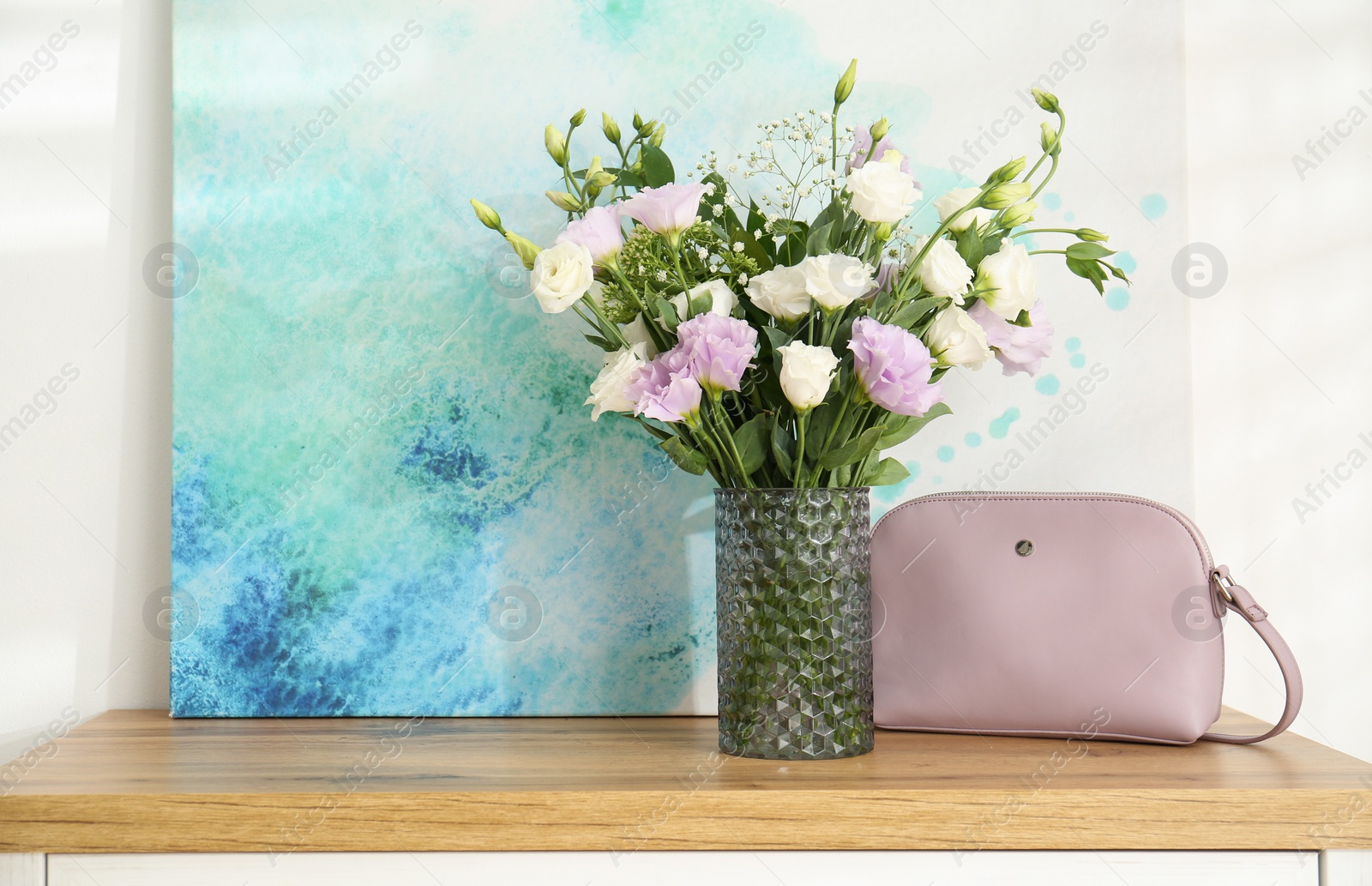 Photo of Bouquet of beautiful Eustoma flowers on chest of drawers in room. Space for text