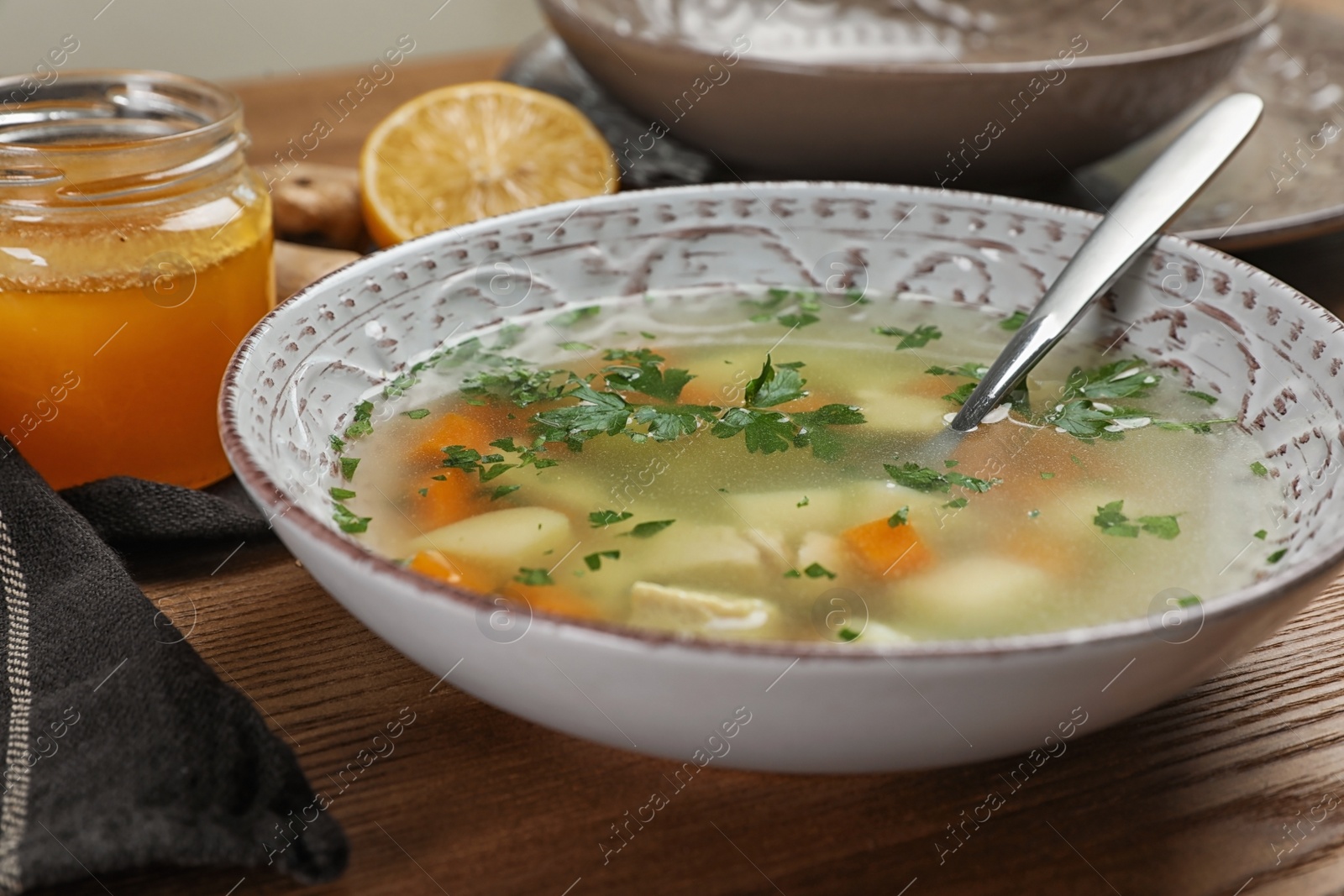 Photo of Bowl of fresh homemade soup to cure flu on wooden table