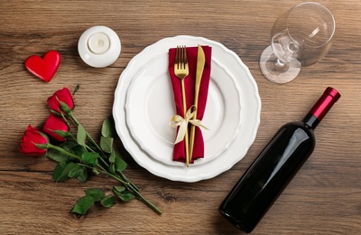 Beautiful table setting for Valentine's Day dinner on wooden background, flat lay