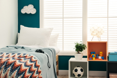 Photo of Modern child room interior with comfortable bed near window
