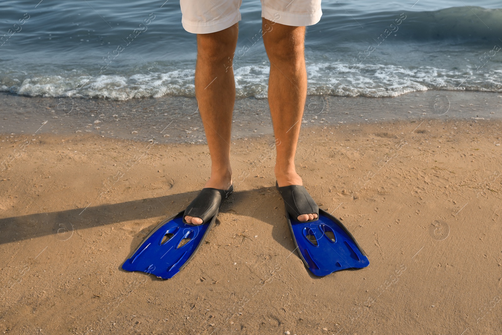 Photo of Man in flippers on sandy beach, closeup