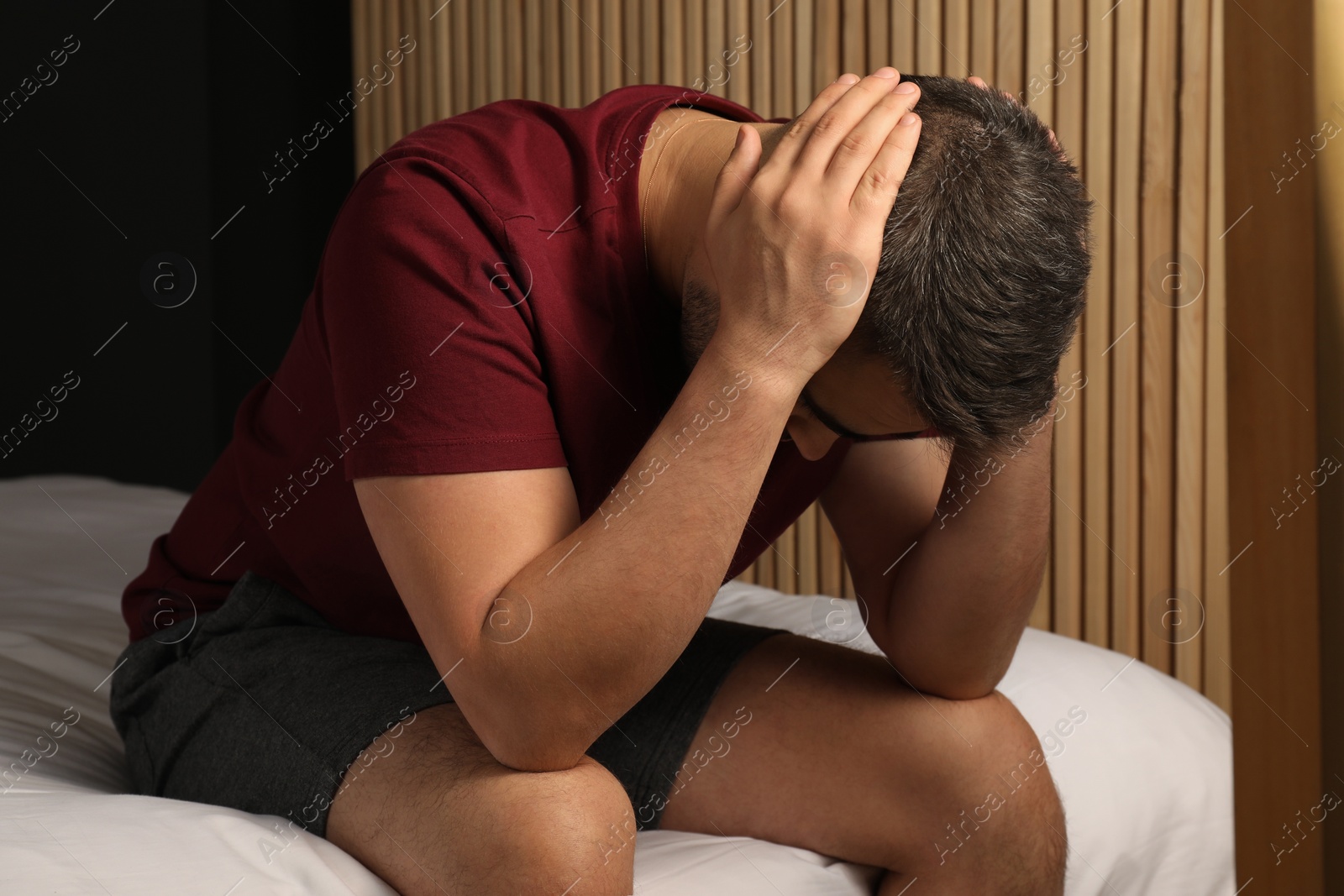Photo of Sad young man on bed at home