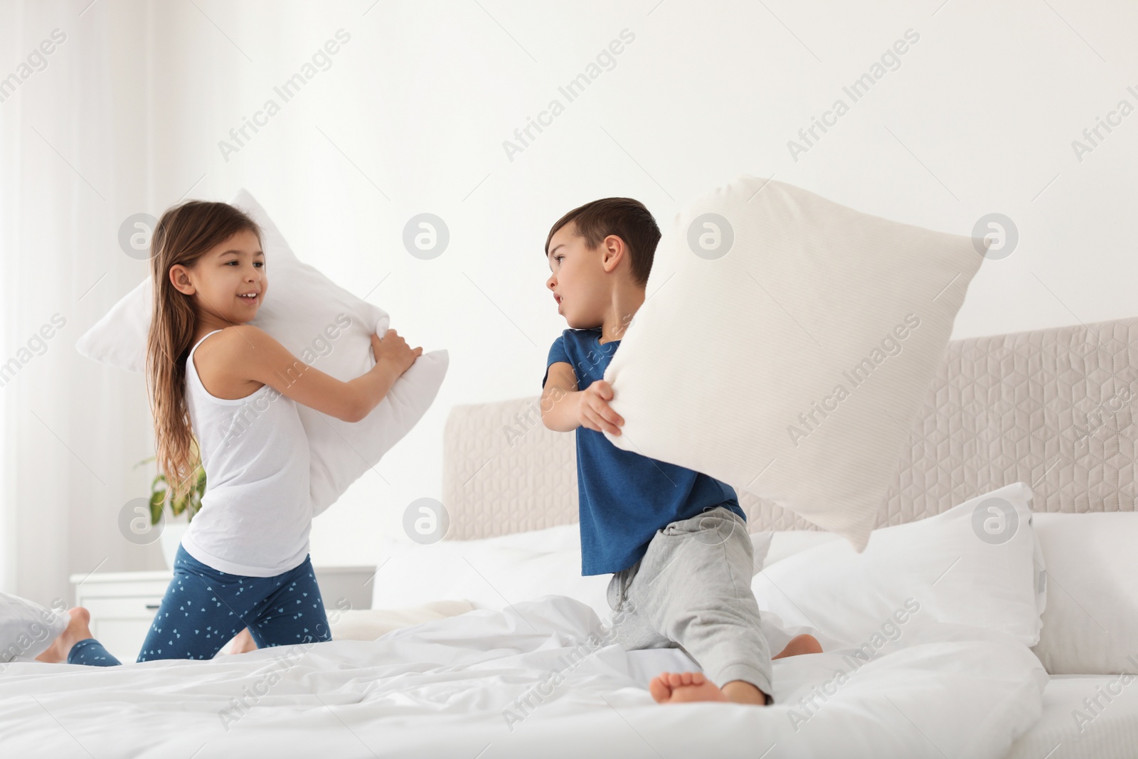 Photo of Happy children having pillow fight in bedroom